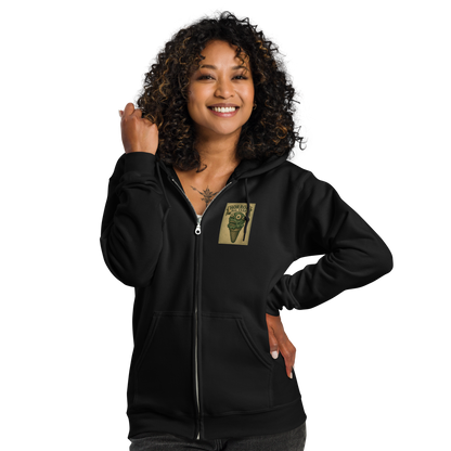 This is a woman with dark curly hair wearing a black zip-up hoodie that is a vintage-style illustration of a zombie-themed ice cream cone with a green, melting undead face and bulging eyeballs. Above the cone, a horror banner reads "Horror All Year" on a distressed parchment background