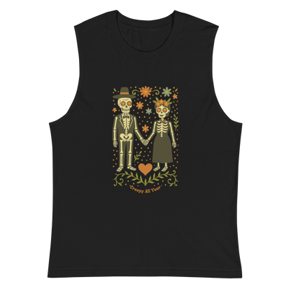 This is a black muscle shirt with a Día de los Muertos–style illustration of a male and female skeleton holding hands, surrounded by marigolds, vines, and folk art patterns. The skeletons wear traditional black clothing, the man in a suit and hat, the woman with a floral crown with a red heart and leaves at the bottom and the text Creepy All Year. Rendered in warm tones of orange, green, and cream, symbolizing eternal love and remembrance