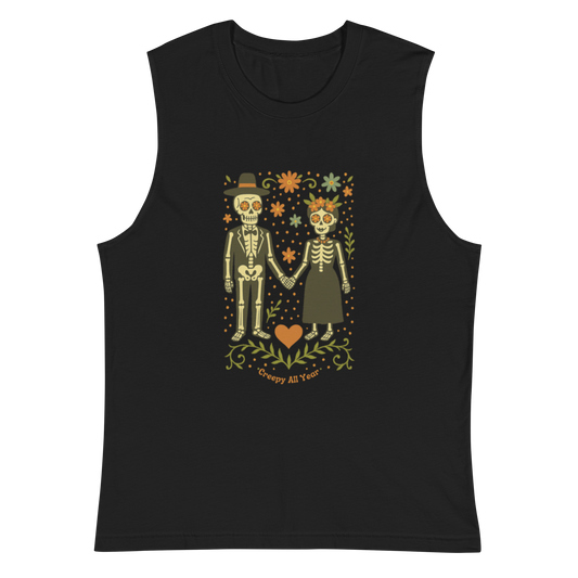 This is a black muscle shirt with a Día de los Muertos–style illustration of a male and female skeleton holding hands, surrounded by marigolds, vines, and folk art patterns. The skeletons wear traditional black clothing, the man in a suit and hat, the woman with a floral crown with a red heart and leaves at the bottom and the text Creepy All Year. Rendered in warm tones of orange, green, and cream, symbolizing eternal love and remembrance