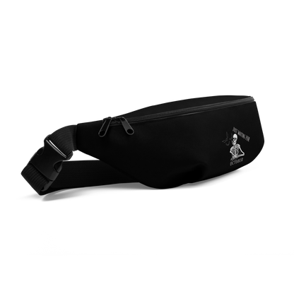 This is a black waist bag fanny pack that has a bored skeleton with his head resting in his hand and he has spider webs and bats around him and the text reads just waiting for October