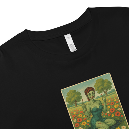 This is a zoom in on a black crop top with a design illustration of a sassy zombie pinup girl standing in a floral field, wearing tattered lingerie and flipping off the viewer with both hands. She has green skin, vintage curls, and a bold attitude. The design blends horror and humor, with a pastel color palette and creepy cute vibes