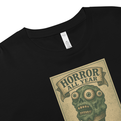 This is a zoom in of a black crop top that is a vintage-style illustration of a zombie-themed ice cream cone with a green, melting undead face and bulging eyeballs. Above the cone, a horror banner reads "Horror All Year" on a distressed parchment background