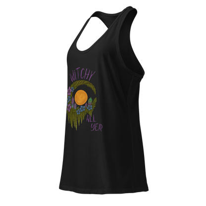 This is the side of a black racerback tank top with a design of a hand-drawn wreath made of moss-covered branches wraps around a glowing sun. The wreath is decorated with purple and blue flowers, small amethyst and fluorite crystals, and strands of hanging moss. The words “Witchy” curve above the wreath and “All Year” sits on the bottom right 
