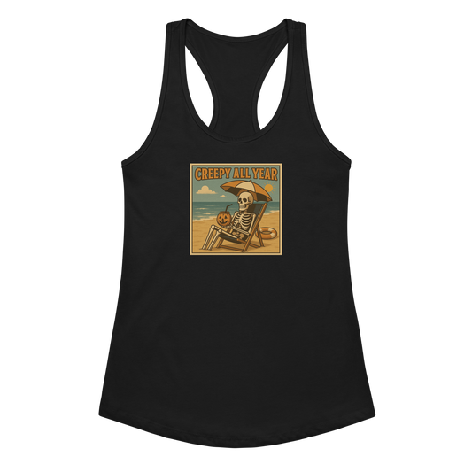 This is a black racerback tank top with a retro-style illustration of a grinning skeleton lounging on a beach chair under an orange umbrella. The skeleton is holding a pumpkin-shaped drink cup with a straw and relaxing by the ocean, with a bright sun in the sky and a life preserver in the sand. The words “Creepy All Year” appear boldly at the top 